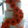 3 tier round Orange and Green Wedding Cake with fresh Gerber Daisies and hand-painted details. 