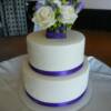 2 tier round White on White Damask Design Wedding Cake with fresh flowers and purple ribbon