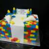 Lego Themed Birthday Cake. The lego men were made out of fondant made to look like they are tearing off the sides of the cake to reveil a lego cake. The lego blocks were made out of fondant, and the entire cake is edible. 