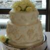 2 tier Grecian style wedding cake. Once covered in white fondant, we added the draping along the bottom as well as the urns and roses throughout the cake. 