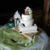 3 tier round and square wedding cake with cherries, a peach and fresh orchids.