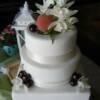 Close up of the three tier wedding cake. Little details include our hand piping above the ribbon around each tier, the fresh cherries and a peach that was picked a couple of minutes before placing it on the cake!