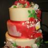 3 Tier round cake (Show Cake). First and third tier in cream fondant, while middle tier was done in a red/white marble. All flowers were hand made and completely edible. 