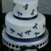 Blue Dragonfly Wedding Cake. This 2 tier wedding cake was our Marble Cake with Classic Buttercream filling. It was then covered in white fondant and had blue fondant draonflies placed on it. It is standing on our 12 in Ceramic cake stand with ribbon holes that is available for rental.