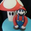 A close-up of the handmade (out of fondant) Mario and the toadstool from the Mario Brother's Nintendo Game. 