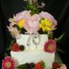 2 tiered 70th Birthday cake made with a Lemon Poppyseed cake and filled with fresh Lemon Curd. The cake was then covered in Vanilla Buttercream and decorated with beautiful spring flowers and fresh fruit!