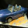 Hand Sculpted 3D 2001 Porsche Boxter Cake. This cake was made for a 50th Birthday Party. Everything you see is edible and made out of sugar. The windshield was poured out of Isomalt sugar and then bent into the curve needed for the car. 