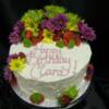 Buttercream covered Birthday cake with fresh flowers and berries.