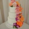 3 tier round wedding cake with handmade (by us) sugar flowers. Mokara Orchids and roses in pinks and oranges were made for this beautiful cake!!