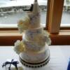 4 tier round wedding cake with hand-painted blue designs provided by the bride. Sitting beside the cake is a Vanilla Gluten Free Mini Cake made for one of the Celiac guests at this wedding. 