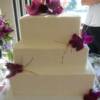 3 tier square wedding cake with purple orchids, calla lillies and twigs. 