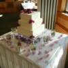 3 tier square wedding cake sitting on our square clear cake stand that was filled with lights, branches and rose petals. 