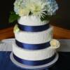 3 tier round Hand piped wedding cake with Navy Blue ribbon and fresh flowers. This cake was delivered to The Harvest Golf Club. 