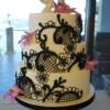 3 tier round white wedding cake with hand piped black lace designs and handmade sugar Dendrobium Orchids. 