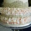 Close up of the pale pink fondant ruffles and silver dragee design on this 2 tier wedding cake.