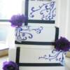 3 tier Square Black Wrapped wedding cake with hand piped purple details with small silver hearts and fresh flowers.