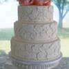 Fondant Lace Applique Wedding cake with an Ivory base and white lace appliques. 3 Pale pink sugar peonies (handmade by us) sit on top of this beautiful cake.