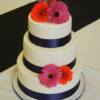 3 tier round wedding cake with Royal Blue ribbon and fondant pearls. Fresh Gerbera Daisies were added on delivery.