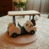 Sculpted Golf Cart made for a surprise Groom's Cake. Little details added to this cake include the Oakley Sunglasses sitting on the dash, Bud Light Beer Bottles and a golf bag replicating the groom's bag. 